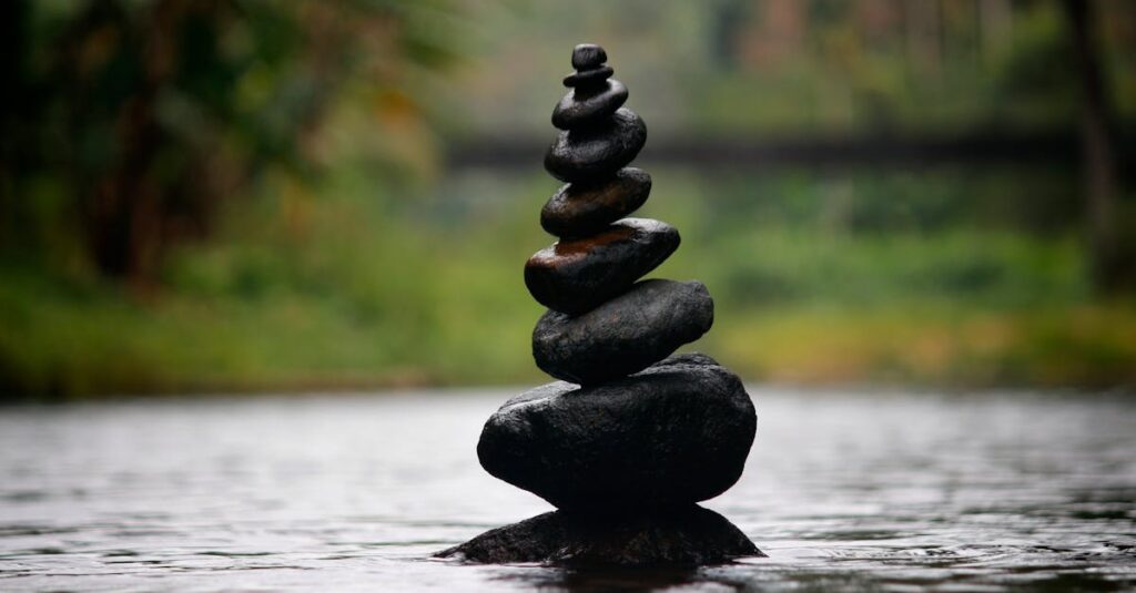 Balanced stones in a serene river evoke a sense of peace and tranquility.