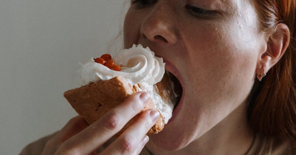 A woman indulges in a dessert slice with whipped cream and cherries.
