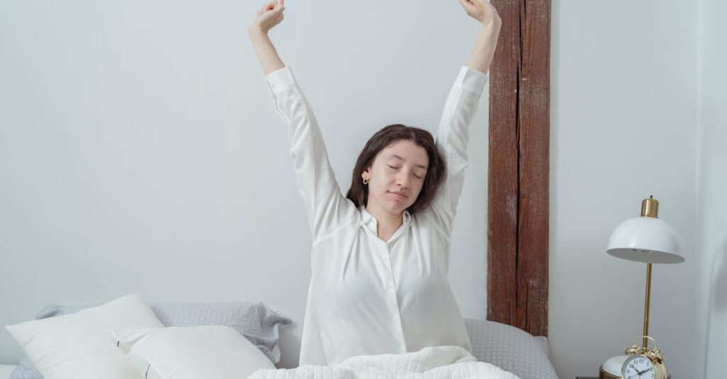 Woman with closed eyes stretching in bed at home during a peaceful morning.